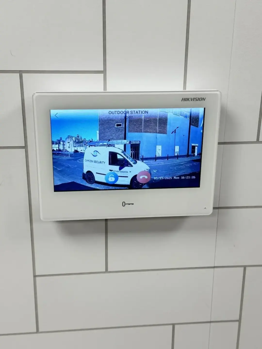 A video entry monitor showing a live camera view of a van outside